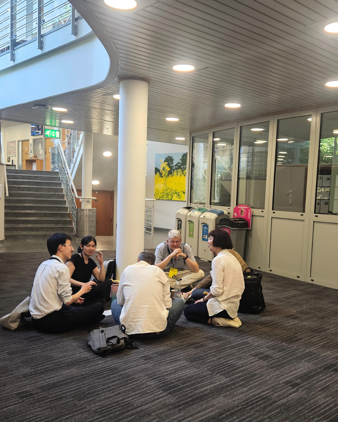 Grafematik participants sitting and chatting in the hallway.